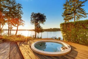 small hot tubs - a small circular hot tub on a deck by the water